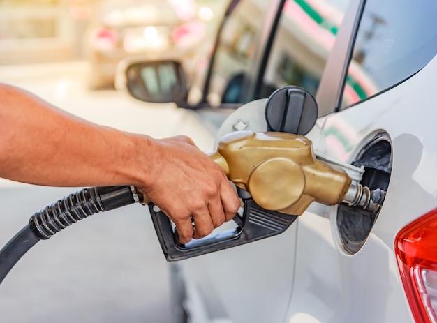 Hand refilling the car with fuel at the gasoline station