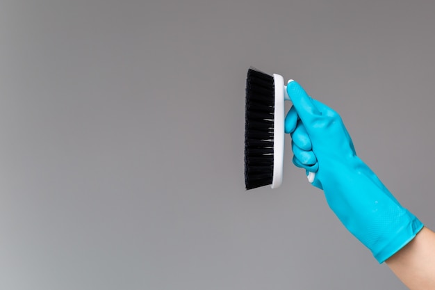 Photo a hand in a rubber glove holds the dishwashing brush 