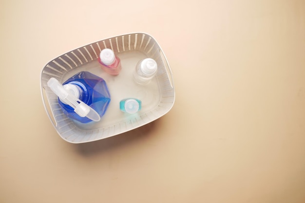 Hand sanitizers in a plastic box on color background