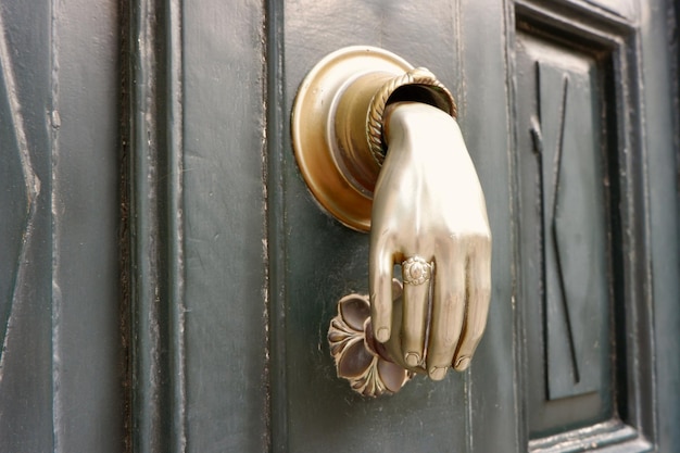 Photo hand shaped knocker on the old vintage door in madrid spain