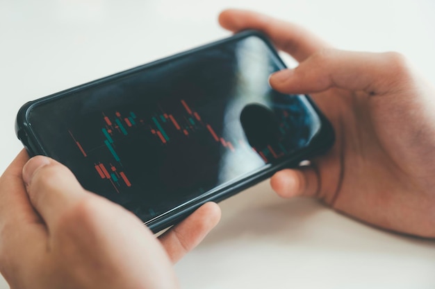 Hand shot of person trading online with phone and tablet