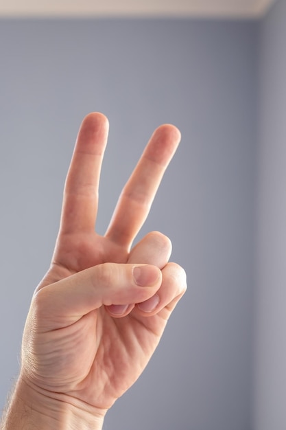 Hand showing with fingers the symbol of victory or number two