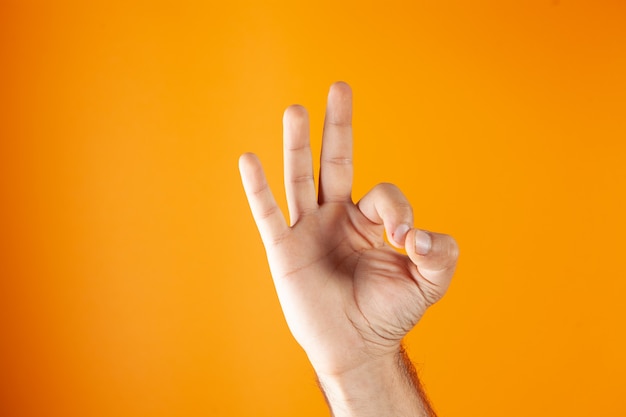 Hand shows ok on orange background