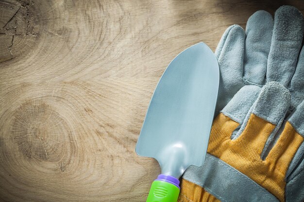 Hand spade pair of safety gloves on wooden board