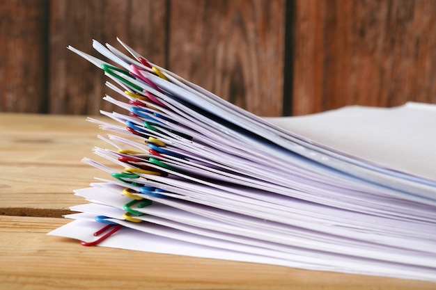 Hand takes stack of documents with binder clips, closeup