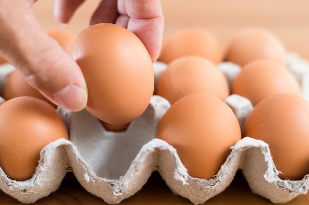 Hand taking an egg from paper pack