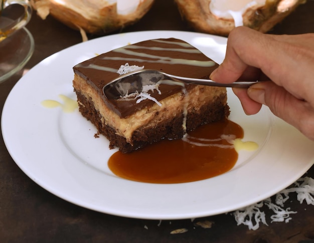 Hand taking spoon a piece of Coconut Cake