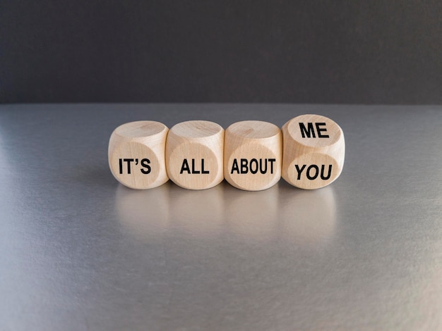 Hand turns dice and changes the expression 'it's all about you' to 'it's all about me'