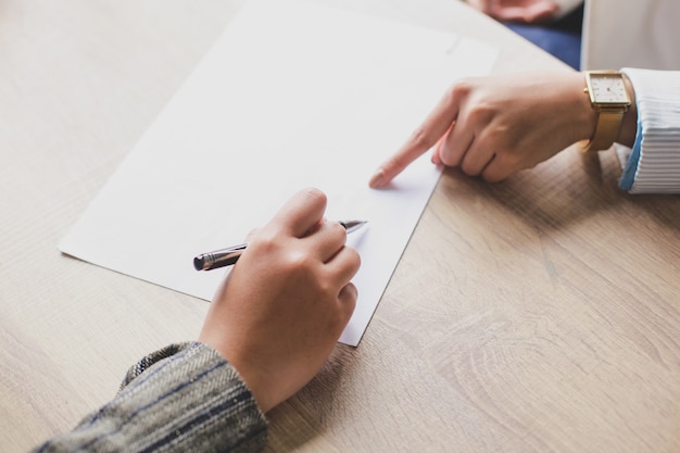 Hand of two woman doing business contract signing on white paper