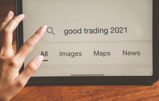 Hand typing for searching about good trading in 2021 for being advice in investment of people