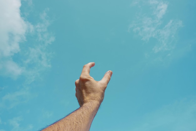 hand up gesturing in the blue sky, feelings and emotions