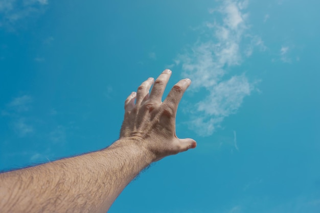 hand up gesturing in the blue sky, feelings and emotions