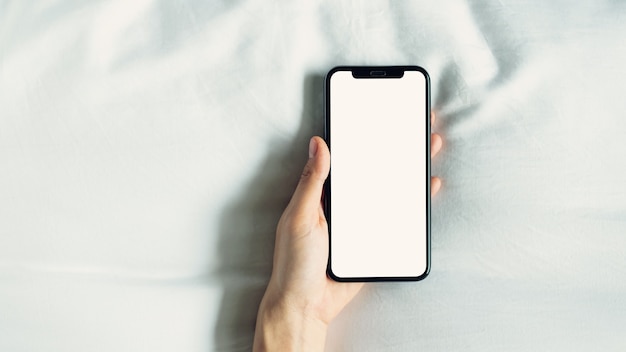 Hand using blank screen of smartphone on room, During leisure time.