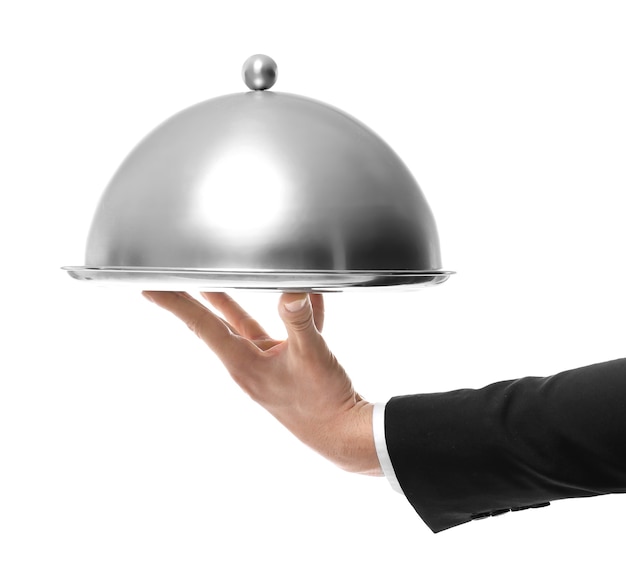 Hand of waiter holding metal tray with cover on white background