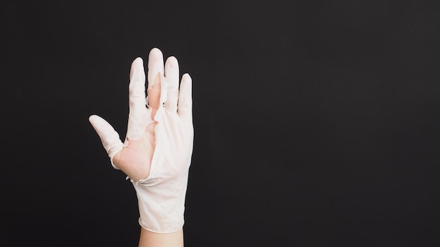 Hand Wearing torn latex glove or torn rubber gloves on black background