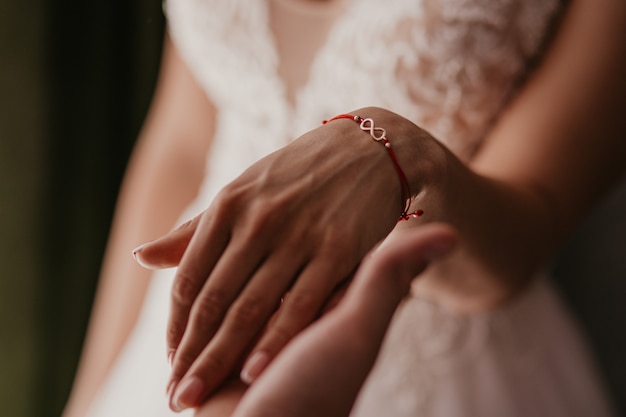 A hand of wedding couple touch each other. Hands newlyweds with wedding rings close up