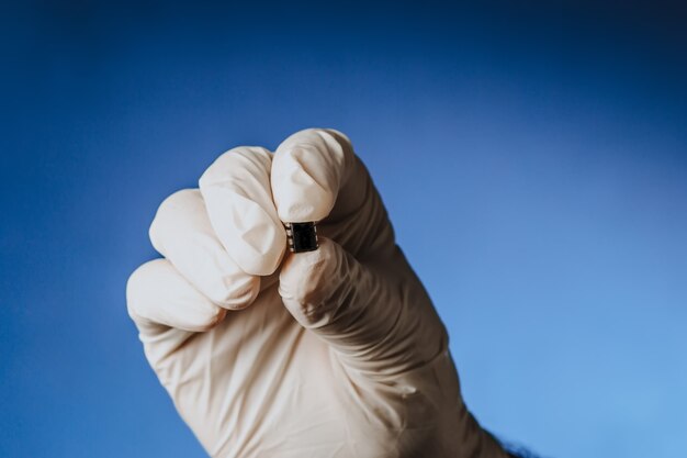 Hand in a white glove holds a chip chipization of people after an epidemic coronavirus copy space