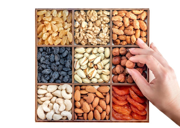 Hand with assorted nuts and dried fruit collection Different superfoods Vegetarian snack of different nuts organic mixed nuts background