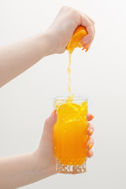 Hand with orange juice on white background