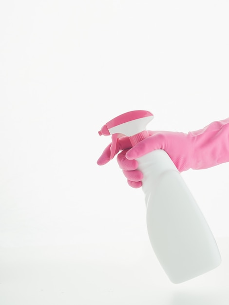 Hand with pink cleaning gloves holding spray bottle for atomizing isolated on a white background