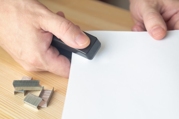 The hand with a stapler connects the documents