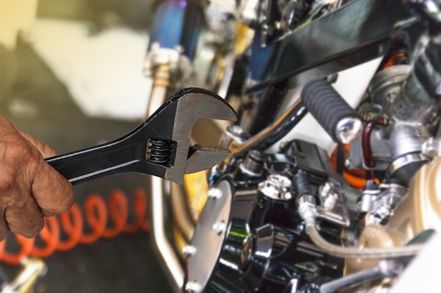 Hand with wrench, Professional mechanic repair and modifications to motorcycle  