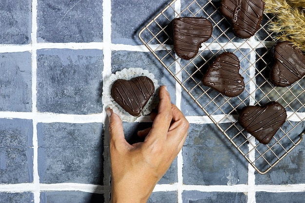 hand woman holding a heart shaped chocolate cookies