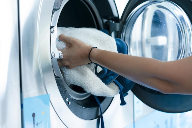 Hand of woman laundry by the washing machine