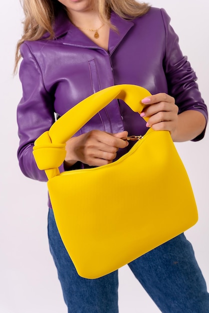 Hand of a woman with a yellow bag on a white background fashion studio