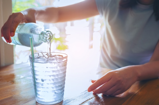 Hand women holding the glass bottle of water 