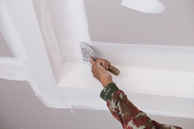 hand of worker using gypsum plaster ceiling joints