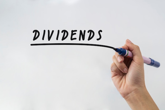 Hand writing Dividends with black marker on transparent