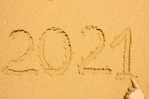 Hand written text on golden wet sand