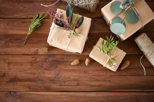 Handcrafted gift boxes with flowers on wooden table