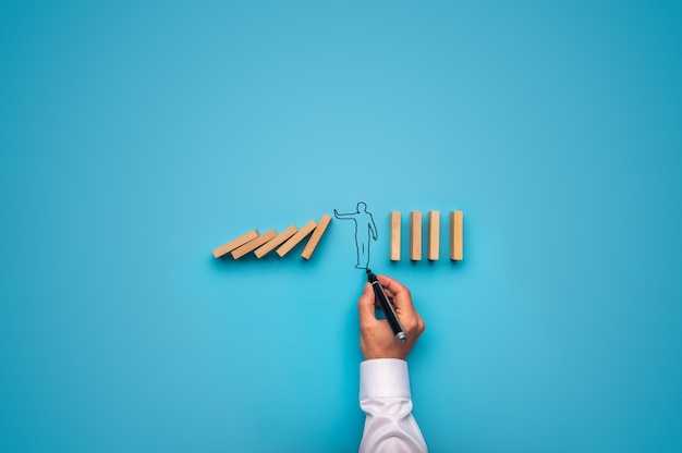 Handdrawn businessman stopping falling dominos