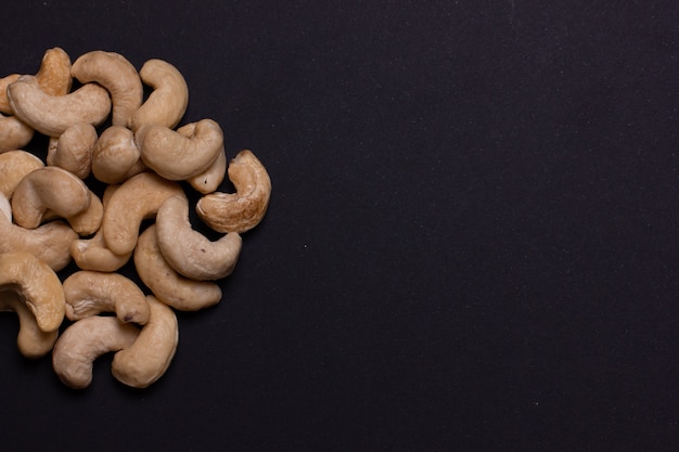 A handful of cashews on a black background closeup A pile of light nuts