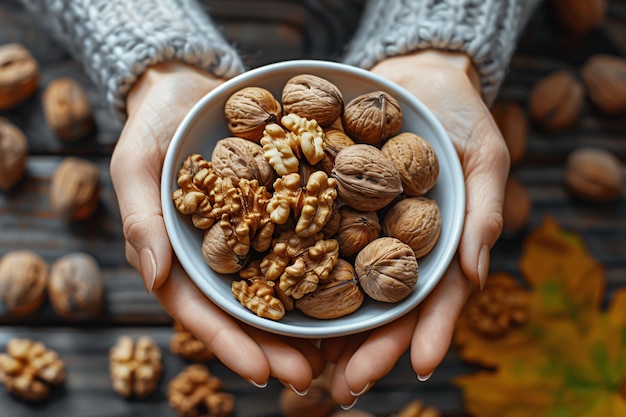 Photo a handful of uncracked walnuts held by a woman on a wooden background promoting healthy nutrition