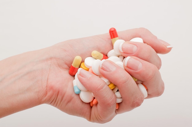 A handful of various pills in a woman's hands Medications against the COVID19 and other conditions and diseases on the grey background Medicine