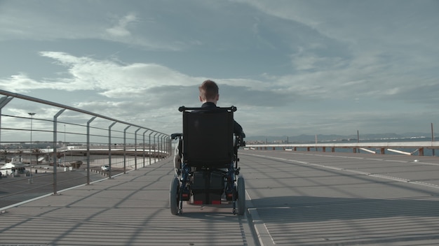 Handicapped boy in electric wheelchair outdoor