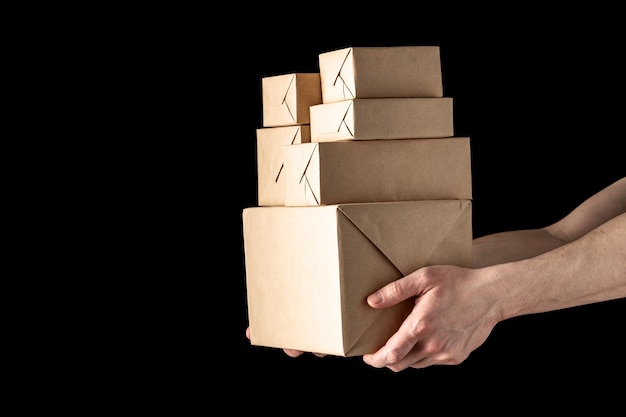 Handing over parcels in wrapping paper isolated on black background