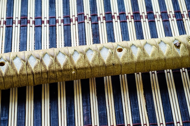 Handle of the japanese sword katana on a bamboo mat