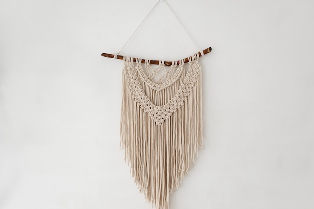 Photo handmade 100 cotton macrame wall decor hanging on a white wall.