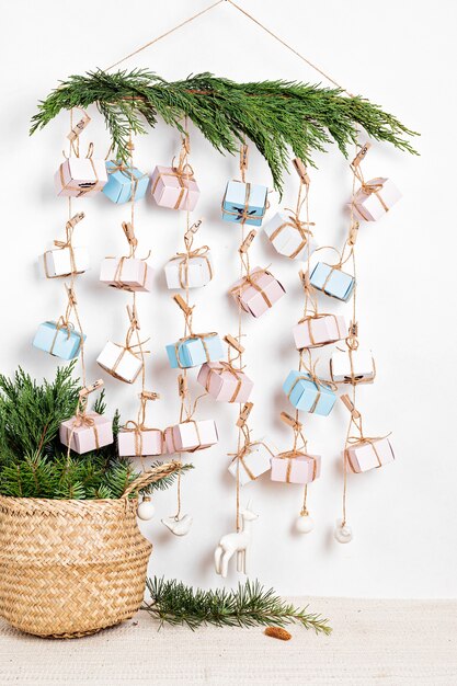 Handmade advent calendar with gift boxes hanging on ropes