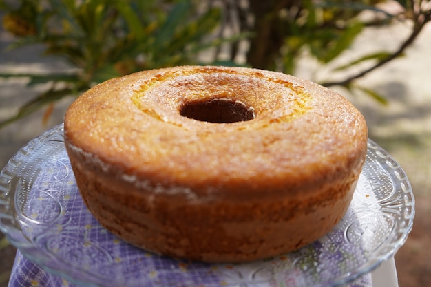 handmade baked corn cake on a dish with some flowers behin