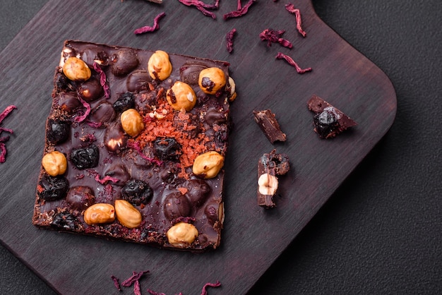 Handmade chocolate with berries nuts and spices on a dark background