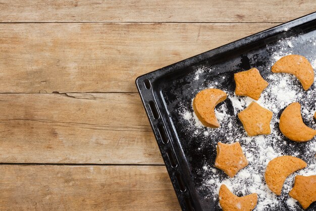 Photo handmade cookies on a baking sheet on a wooden surface. flat lay, top view.