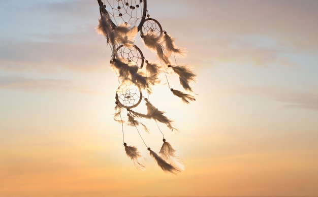 Handmade dream catcher against beautiful sunset sky Space for text