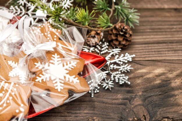 Handmade gingerbread cookies with christmas decorations over wooden background