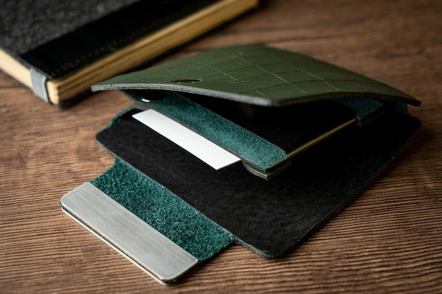 Handmade green wallet made of genuine leather on a wooden background Closeup top view