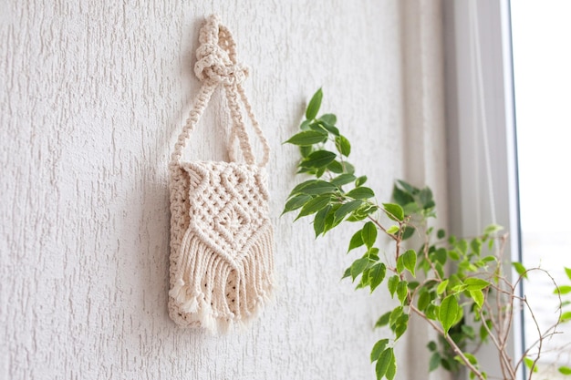 Handmade macrame bag on white background ECO friendly natural macrame cotton bag for woman Hobby knitting handmade macrame Modern summer concept